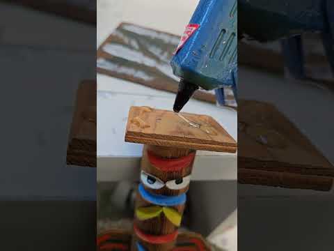 Nat (me) {off-screen} hotglueing Totem Pole on cardboard