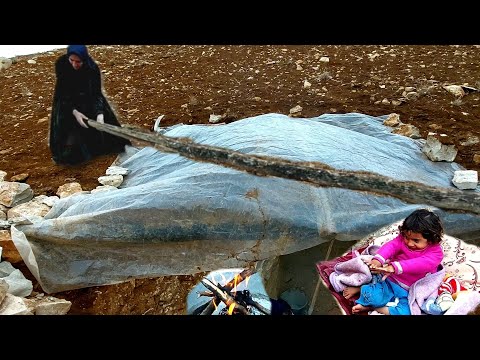 A mother in a shelter struggles to keep herself and her daughter warm on a cold, rainy day.