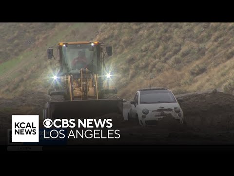 Drivers rescued after hillside gives way, trapping cars in mud