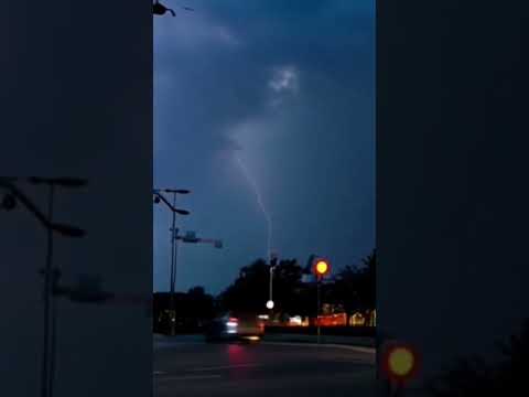 Lightning and thunder strike a car driving in the street