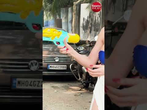 Sherlyn Chopra PLAYS with water gun and water balloons as she WISHES paps Happy Holi 🎉